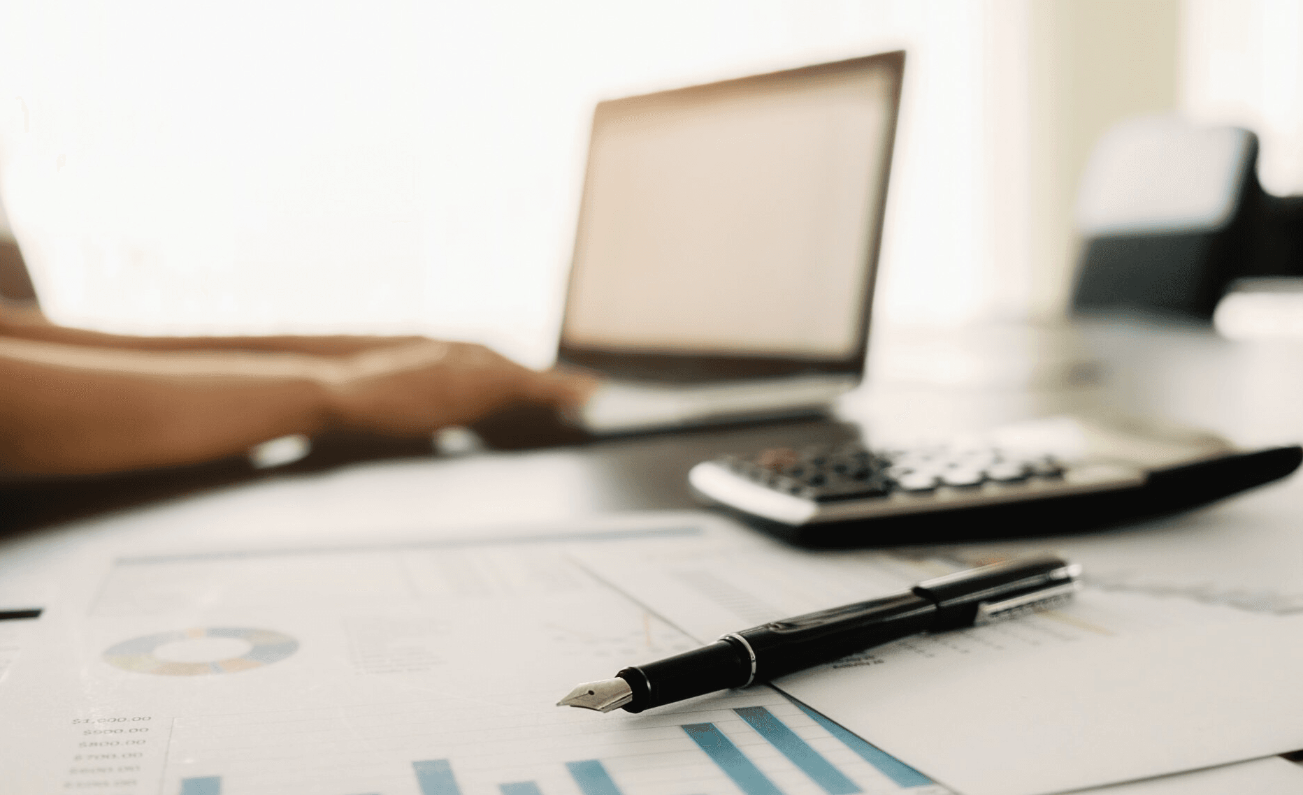 bureau met rekenmachine en laptop